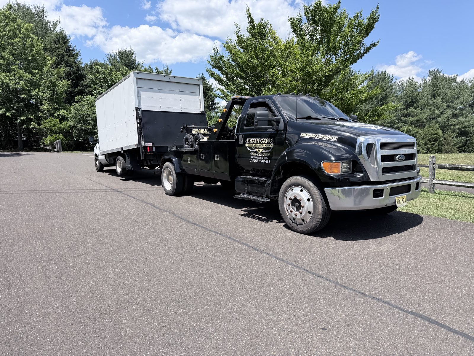 Chain Gang medium-duty tow truck transporting a box truck in Central New Jersey