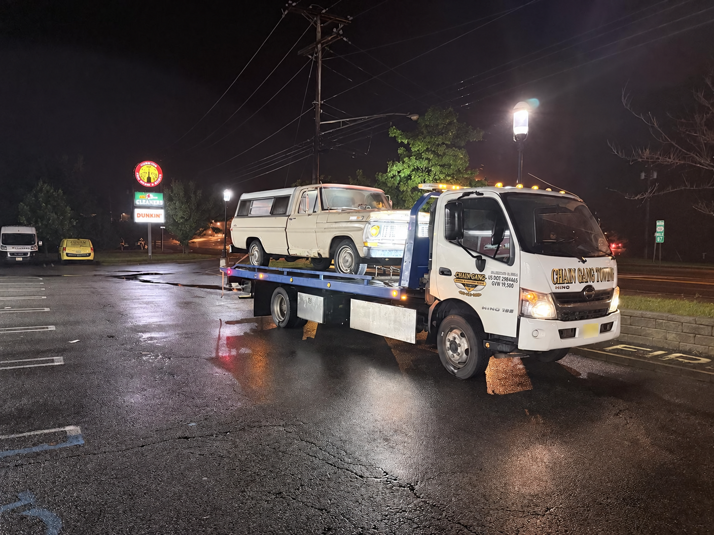 A 1970 Ford F-100 on a Chain Gang flatbed during a late-night tow from Chester to Kendall Park, New Jersey.