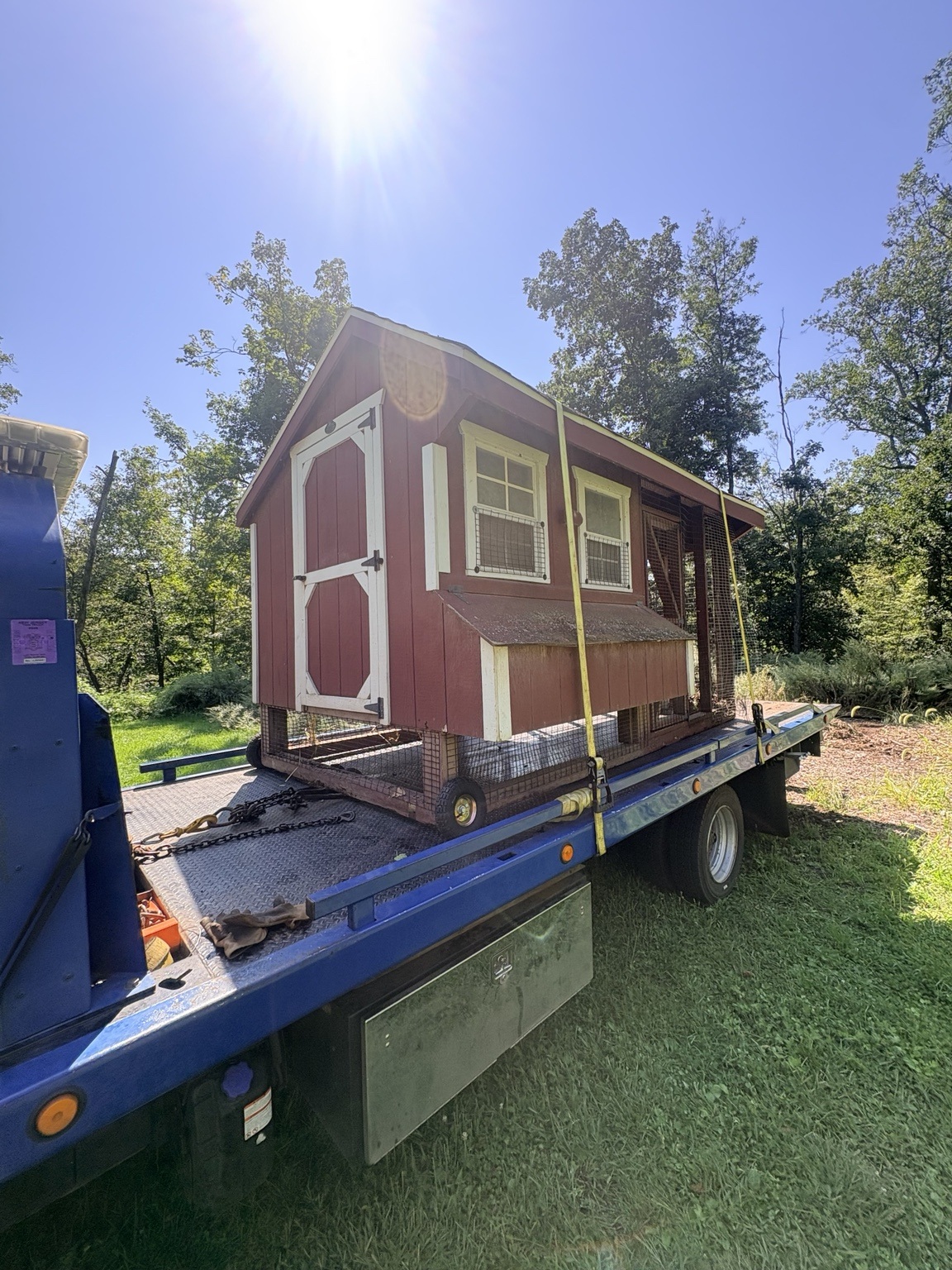 A chicken coop secured on a Chain Gang flatbed for transport to a new location.