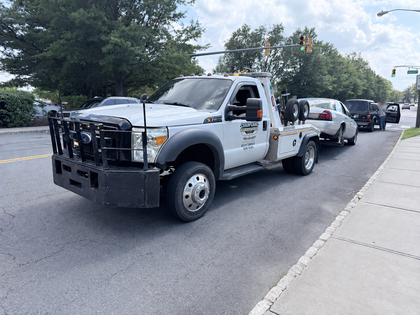 Chain Gang wrecker towing a disabled sedan from a Hillsborough roadway.