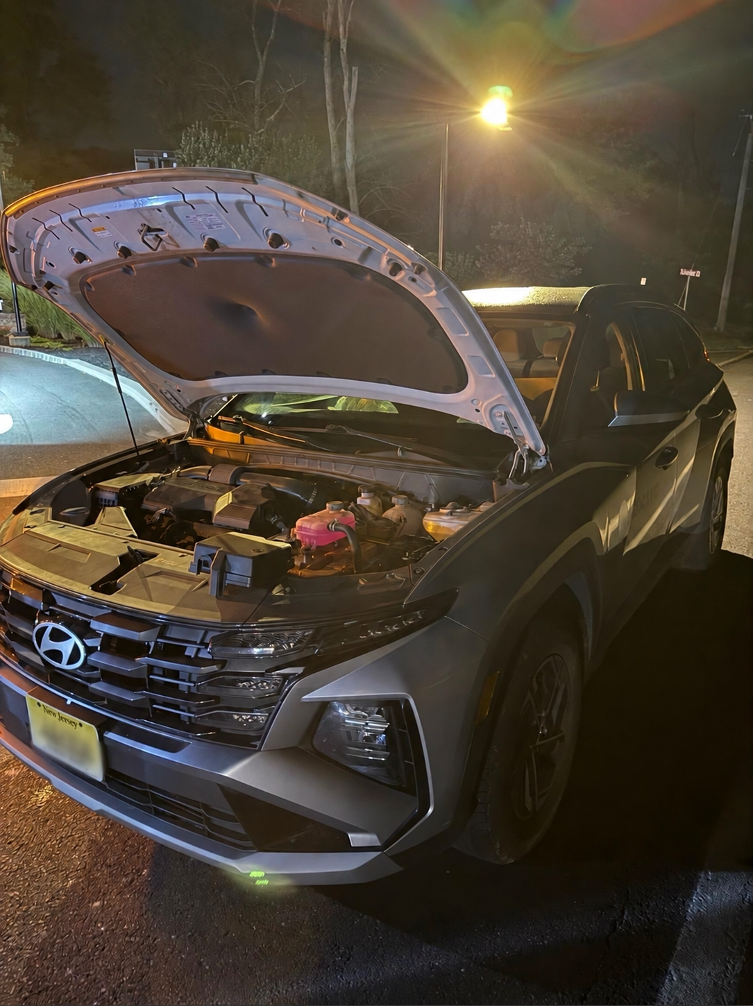 Late-night jump-start for a Hyundai SUV with its hood open in Central New Jersey.