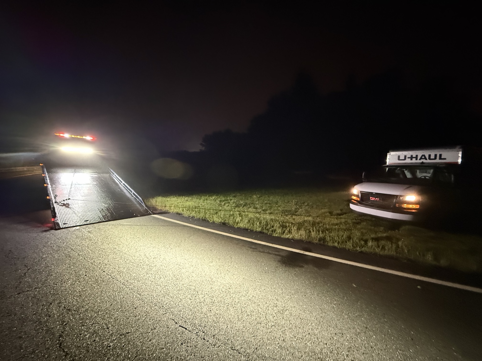 Chain Gang flatbed assisting a U-Haul truck during a nighttime winch-out in Green Brook.