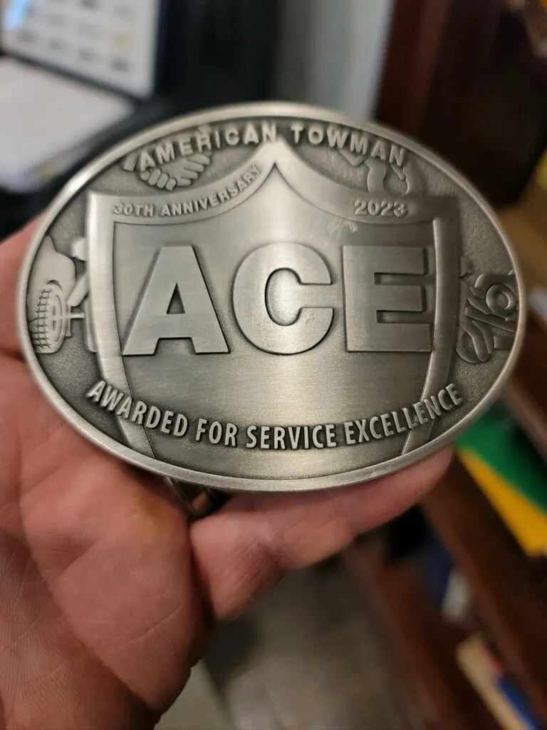 American Towman ACE 30th anniversary 2023 service excellence buckle held by Chain Gang Towing owner